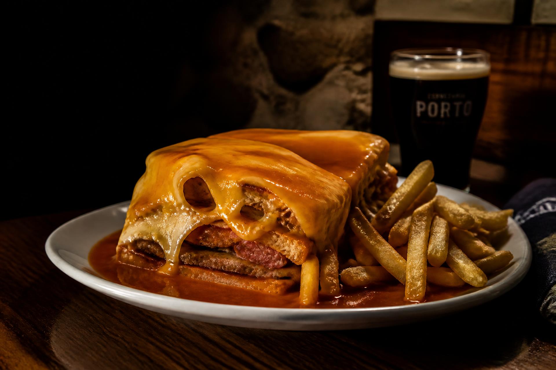 Francesinha portuguesa coberta de queijo derretido e molho abundante